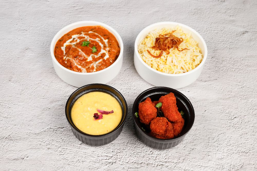 The three-course lunch — butter chicken, saffron rice, dal and crispy bites