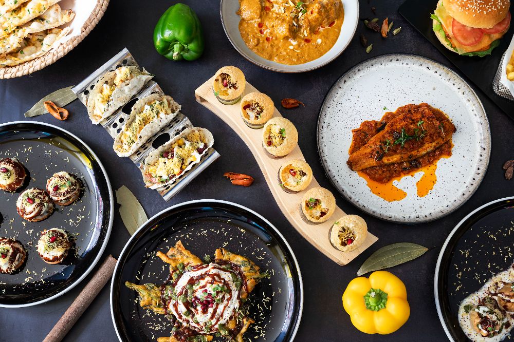 Delhi street snacks — pani puri on the board, kale pakora chaat, naan basket and butter chicken