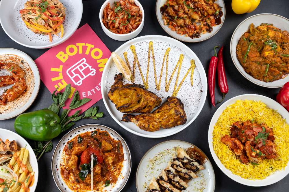 A Bell Bottom spread — tandoori chicken, saffron rice, curries, chaat and the pink menu card